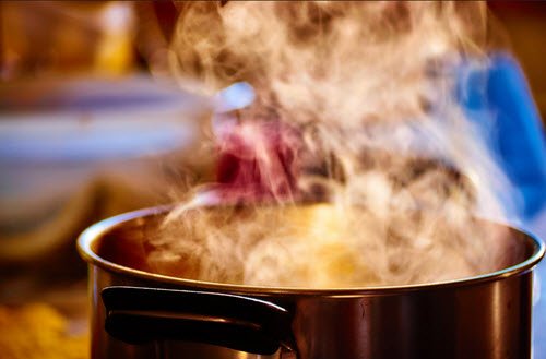 Steaming pot on a stovetop in a kitchen.