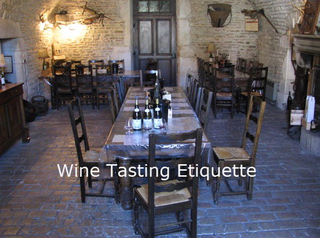 Rustic wine tasting room with long table and bottles of wine.