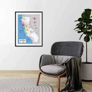 Framed California wine map on a white wall above a grey armchair in a minimalist room.