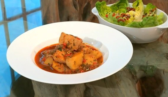 A bowl of Marmitako Basque fish stew and a bowl of salad.