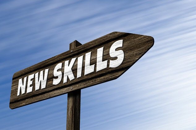 A wooden signpost with the text "NEW SKILLS" against a blue sky background.