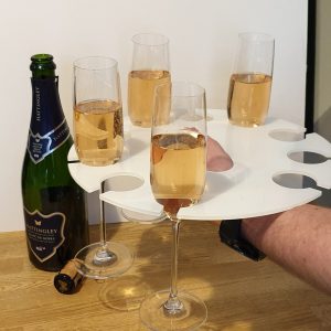 Hand holding a tray with glasses of champagne for a tasting.