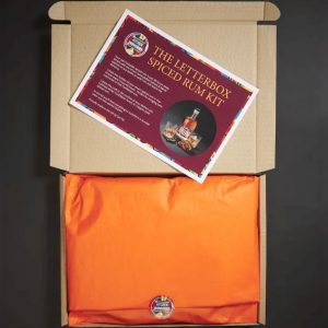 Closed spiced rum making kit in a box, with an orange wrapping and an informational card on top.