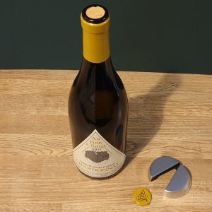 Bottle of Au Bon Climat Chardonnay with a foil cutter and cork.