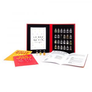 Open red box displaying vials for identifying wine aromas alongside booklets titled 'White Wines' and 'Red Wine,' part of 'LE NEZ DU VIN' by Jean Lenoir.