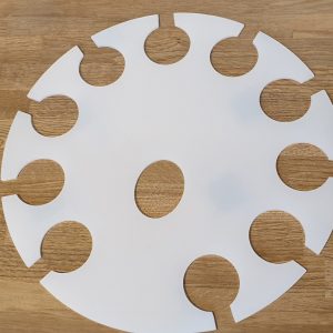 Round white tray with multiple circular cut outs designed to hold glasses.