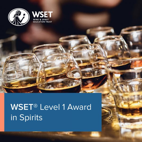 Glasses of spirit on a table in the the background with a blue title box in the bottom left corner saying "WSET Level 1 Award in Spirits".