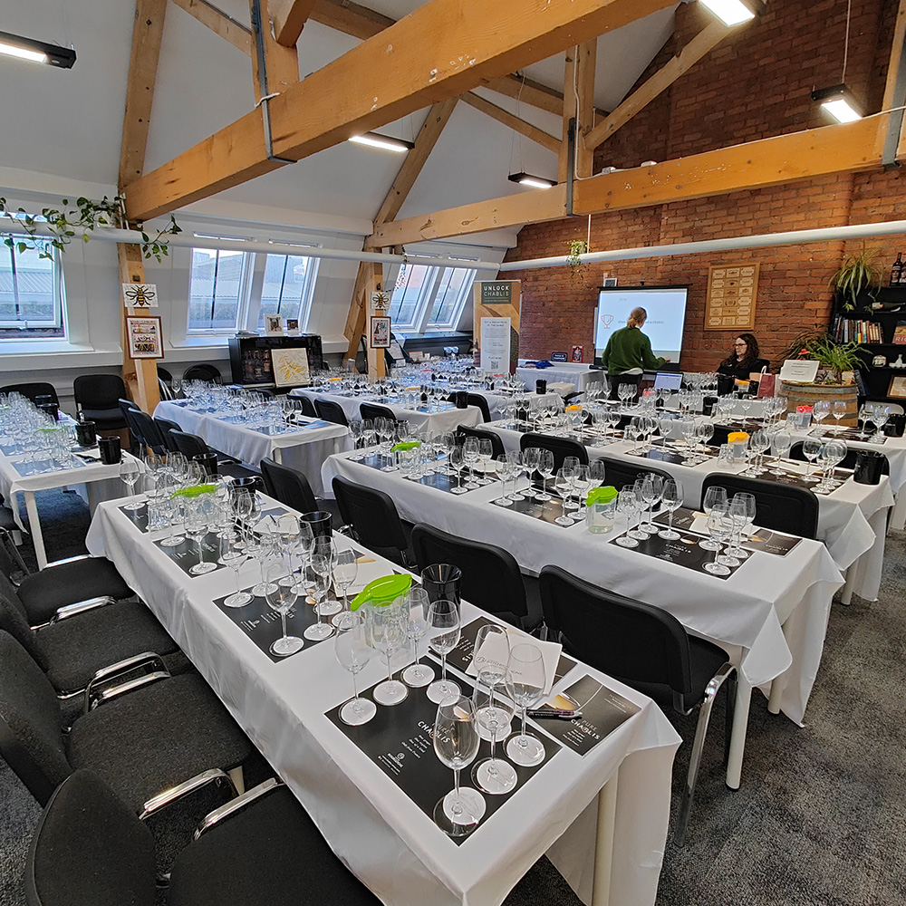 A multiple table and chairs, with many glasses, cups and jugs on them.